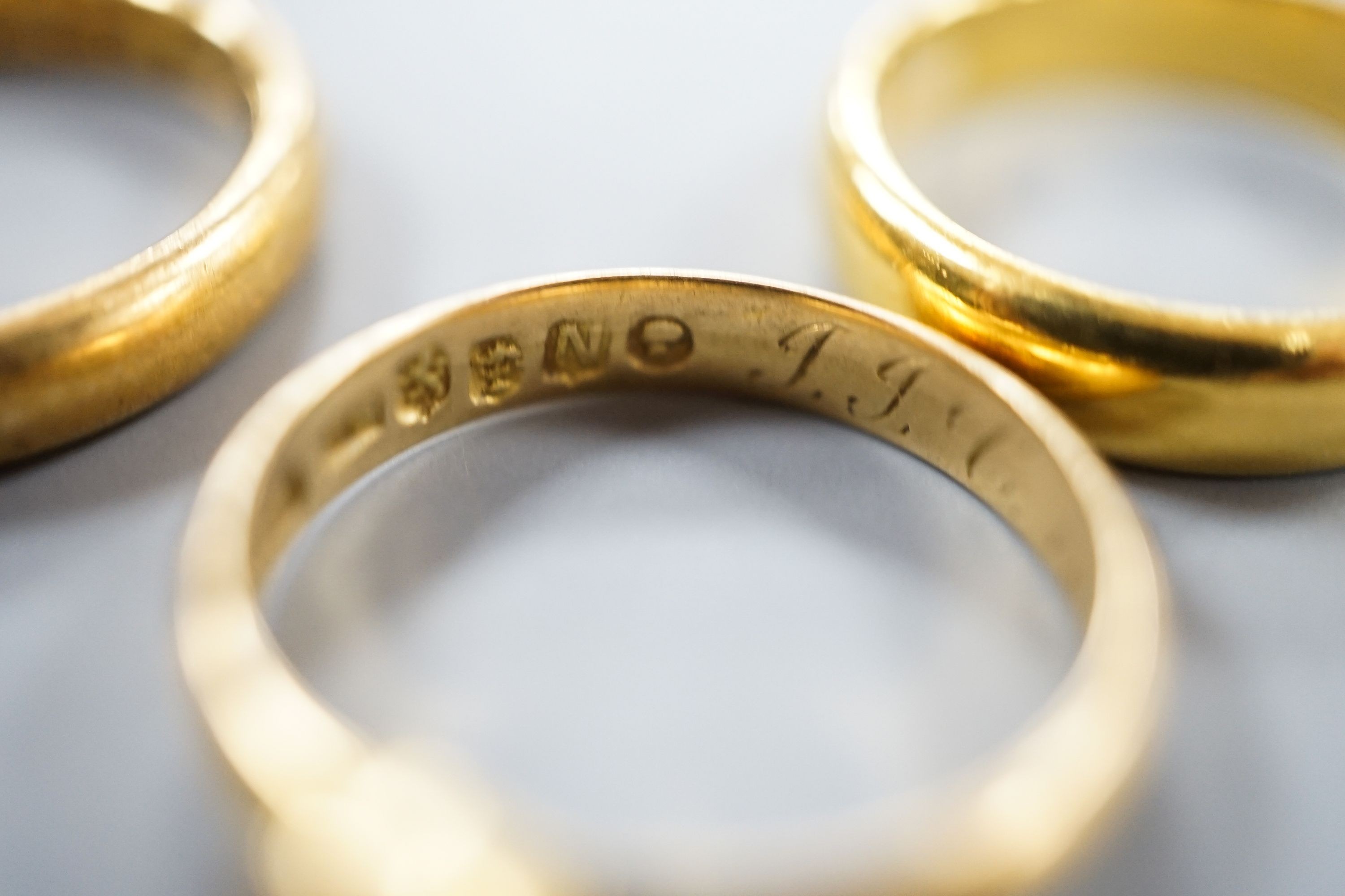 Two 22ct gold wedding bands, 10.3 grams, a George V 18ct gold wedding band and a Victorian 18ct gold shank, 6.6 grams.